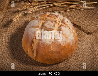 loaf of fresh homemade sour dough bread on burlap background Stock Photo