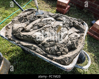 A barrow full of ready made cement for wall building in the garden Stock Photo