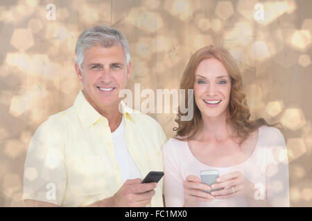 Composite image of casual couple sending text messages Stock Photo