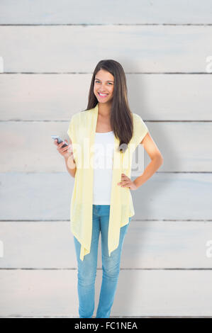 Composite image of happy casual woman sending a text Stock Photo