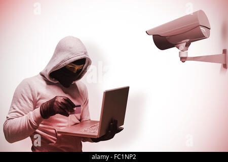 Composite image of hacker using laptop to steal identity Stock Photo