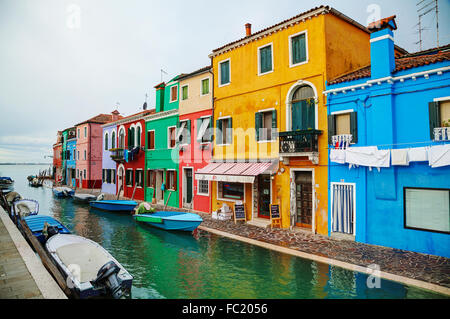 BURANO, ITALY - NOVEMBER 23: Brightly painted houses at the Burano canal on November 23, 2015 in Burano, Venice, Italy. Stock Photo