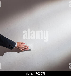 Man's hand turns on the light Stock Photo