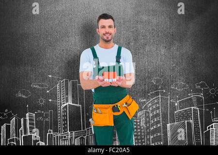 Composite image of happy construction worker holding house model Stock Photo