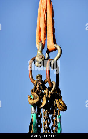 Heavy duty industrial chains and hooks isolated against blue sky Stock Photo