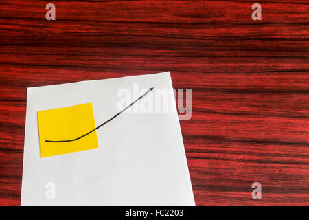 Sheet of paper with a yellow sticky note. A curve graph printed on both. Stock Photo