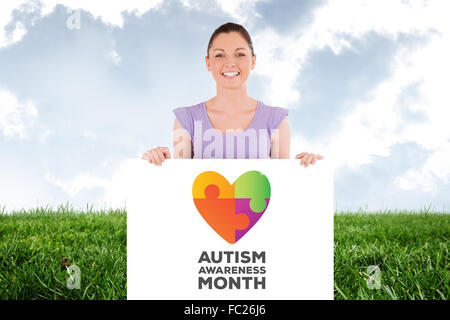 Composite image of portrait of a charming woman posing behind a billboard while standing Stock Photo
