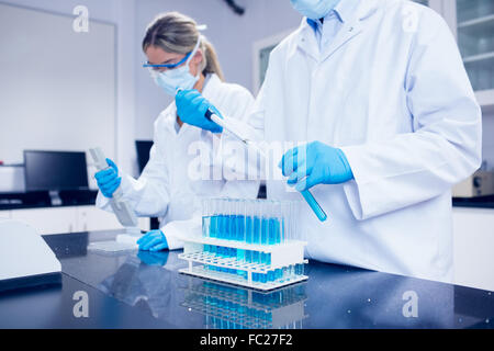 Science students using pipettes to fill test tubes Stock Photo