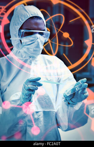 Composite image of protected scientist dropping dangerous liquid in a petri dish Stock Photo