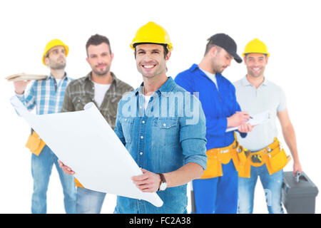 Composite image of happy architect holding blueprint in house Stock Photo