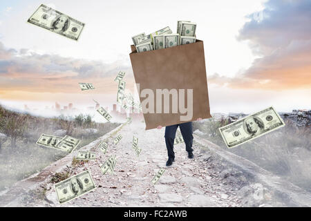 Composite image of businessman carrying bag of dollars Stock Photo