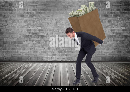 Composite image of businessman carrying something heavy with his back and hands Stock Photo