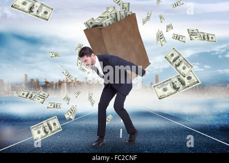 Composite image of businessman carrying bag of dollars Stock Photo