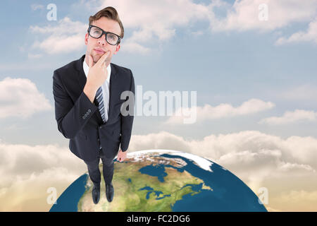 Composite image of thoughtful geeky hipster businessman looking up Stock Photo