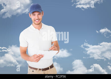 Composite image of happy delivery man holding clipboard Stock Photo