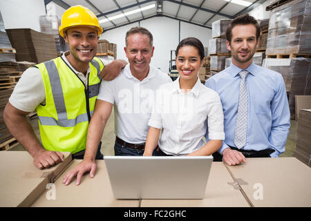 Warehouse managers and worker smiling at camera Stock Photo