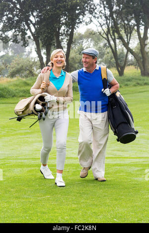 Golfing couple smiling at each other on the putting green Stock Photo