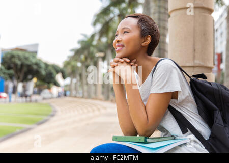 thoughtful young African college girl sitting outdoors on campus Stock Photo