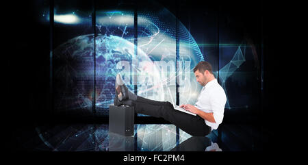 Composite image of businessman with feet up on briefcase Stock Photo