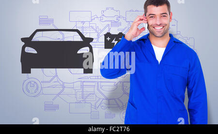 Composite image of portrait of smiling male mechanic using mobile phone Stock Photo