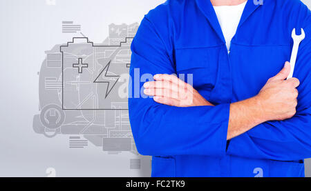 Composite image of male mechanic holding spanner on white background Stock Photo