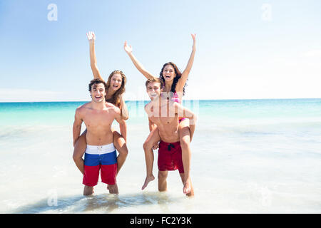 Handsome men giving piggy back to their girlfriends Stock Photo