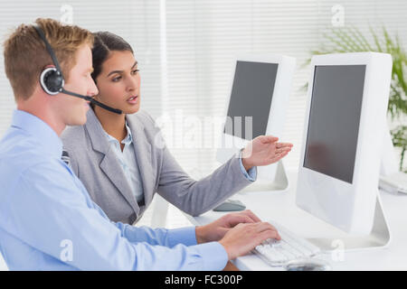 Business team working on computers and wearing headsets Stock Photo