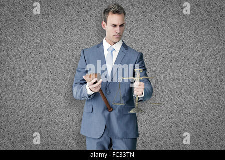 Composite image of businessman holding scales of justice Stock Photo