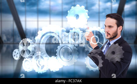 Composite image of focused businessman pointing in suit jacket Stock Photo