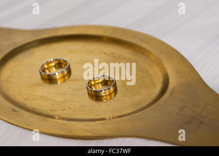 Two gold wedding rings on a gold tablet Stock Photo