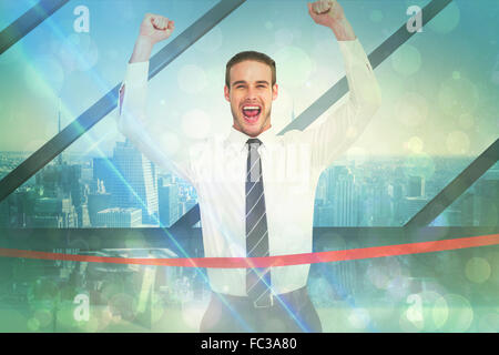 Composite image of businessman crossing the finish line and cheering Stock Photo