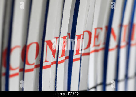 'CONFIDENTIAL' paper through a shredder. Stock Photo