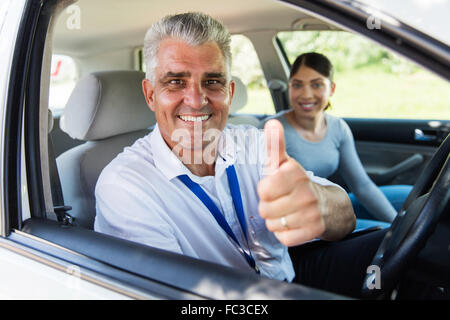 handsome senior driving instructor giving thumb up Stock Photo