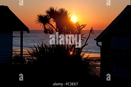 Swansea, UK. 20th January, 2016. Early morning walkers watch the sun rise over the North Devon coastline as seen from Langland Bay this morning on a cold and crisp winters morning. Credit:  Phil Rees/Alamy Live News Stock Photo