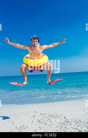 Man wearing flippers and rubber ring at the beach Stock Photo