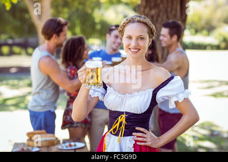 Pretty oktoberfest blonde toasting in the park Stock Photo