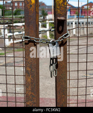 Rusty gates chained and padlocked. Stock Photo