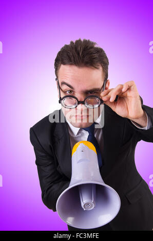 Young businessman with loudspeaker against the gradient Stock Photo