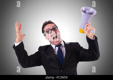 Young businessman with loudspeaker against the gradient Stock Photo