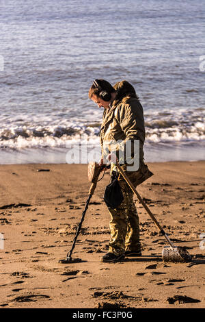 Aberystwyth, West Wales, UK. 20th January 2016. People are out and about enjoying the glorious sunshine and blue skies albeit cold.  A man is metal detecting on the North Beach. Credit:  Trebuchet Photography / Alamy Live News Stock Photo