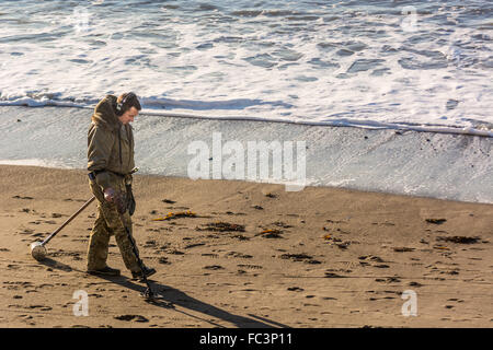 Aberystwyth, West Wales, UK. 20th January 2016. People are out and about enjoying the glorious sunshine and blue skies albeit cold.  A man is metal detecting on the North Beach. Credit:  Trebuchet Photography / Alamy Live News Stock Photo