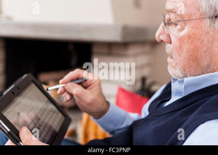 senior man texting message on tablet Stock Photo