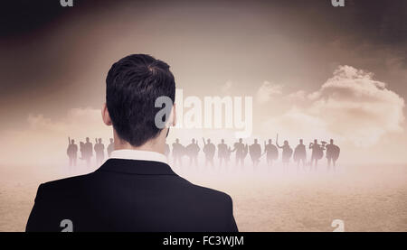 Composite image of rear view of businessman in suit standing Stock Photo