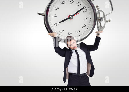 Composite image of businessman in suit lifting up something heavy Stock Photo