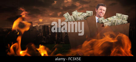 Composite image of businessman carrying bag of dollars Stock Photo