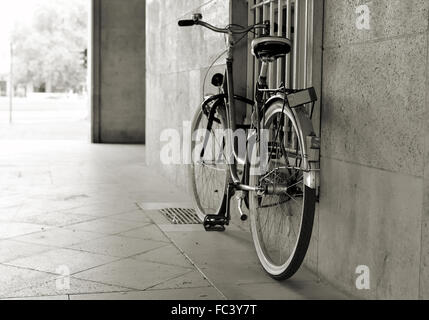 an abandoned bicycle on a house wall Stock Photo