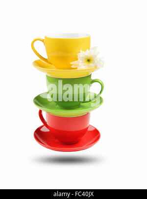 Three different colored cups facing each other on a white background Stock Photo