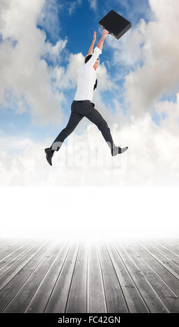 Composite image of businessman leaping with his briefcase Stock Photo