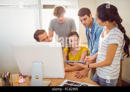 Creative business team gathered around a tablet Stock Photo