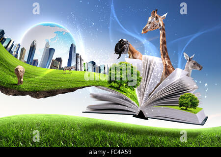 Open book with green nature world coming out of its pages Stock Photo